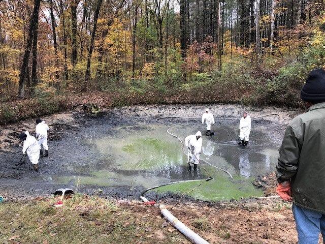 Utility workers investigating a water pond